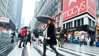 People cross the street outside the Macy’s Herald Square store in New York City on Dec. 17, 2023.