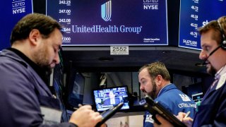 Traders work at the post where UnitedHealth Group is traded on the floor of the New York Stock Exchange.