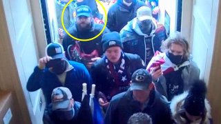 In this image from U.S. Capitol Police security video, released and annotated by the Justice Department in the Statement of Facts supporting an arrest warrant, Taylor Taranto, circled in yellow, enters the U.S. Capitol through the Upper West Terrace door on Jan. 6, 2021, in Washington. A Capitol riot suspect who had guns and hundreds of rounds of ammunition in his van when he was arrested near former President Barack Obama’s Washington home has been indicted on federal firearms charges. Taranto was already facing misdemeanor charges stemming from his alleged involvement in the Jan. 6 riot.