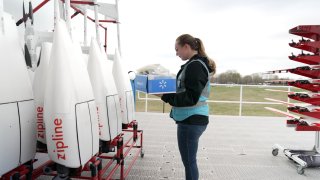 A drone operator loads a Walmart package into Zipline’s P1 fixed-wing drone for delivery to a customer home in Pea Ridge, Arkansas, on March 30, 2023.