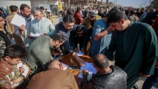 FILE – Supporters of the Shiite cleric Muqtada al-Sadr sign a pledge to stand against homosexuality or LGBTQ, outside a mosque in Kufa, Iraq, Friday, Dec. 2, 2022.
