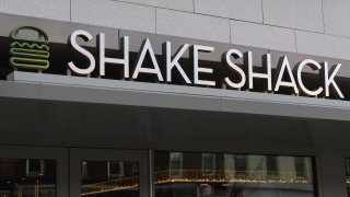 The corporate logo for Shake Shack is displayed on the front of their restaurant on December 30, 2023