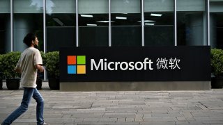 A man walks past Microsoft’s local headquarters in Beijing on July 20, 2021.