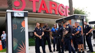 FILE - Police officers stand outside of a Target store as a group of people across the street protest against Pride displays in the store on June 1, 2023, in Miami.