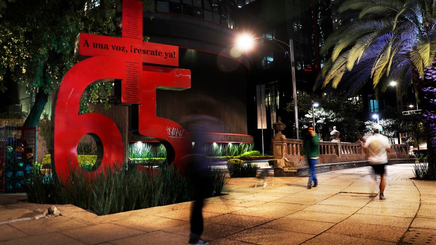 FILE – Pedestrians walk by a sculpture of a bright red number 65 that pays homage to the coal miners killed in the 2006 Pasta de Conchos mine accident, in Mexico City. Authorities announced on Wednesday, June 12, 2024, the discovery of the skeletal remains of some of the 63 miners who have remained missing for almost two decades. Sixty-five miners died in the explosion, but authorities only found two of the miners’ bodies.