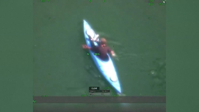 A man paddles in the river on a kayak