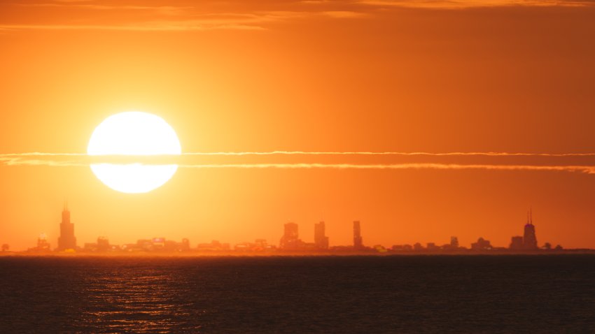 The sun sets behind Chicago’s skyline as seen from Indiana Dunes State Park in Chesterton, Indiana.