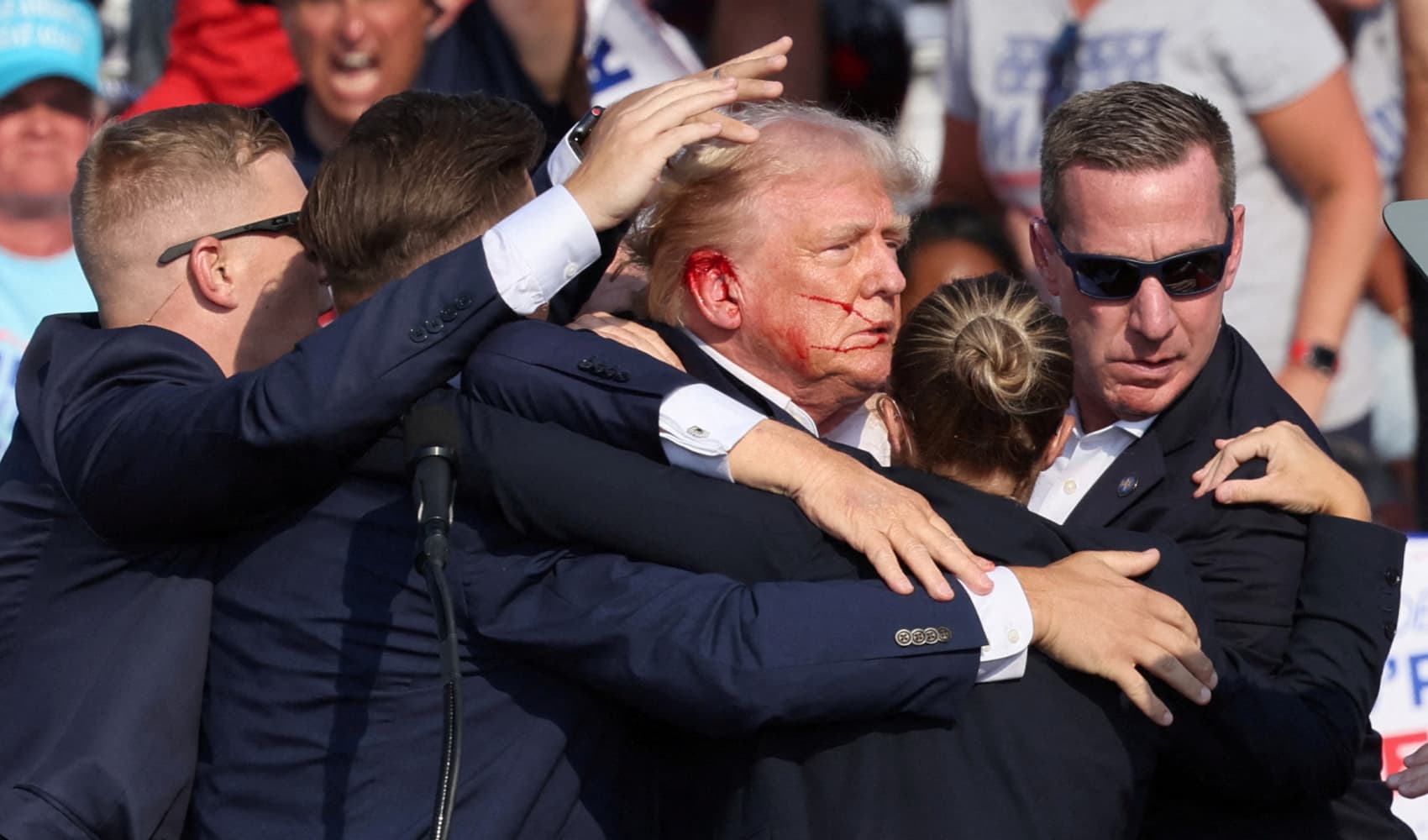 Republican presidential candidate and former U.S. President Donald Trump is assisted by the Secret Service after gunfire rang out during a campaign rally at the Butler Farm Show in Butler, Pennsylvania, U.S., July 13, 2024.