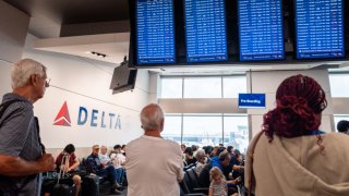 ATLANTA, GEORGIA – JULY 23: Travelers wait to board their delayed flight at the Hartsfield-Jackson Atlanta International Airport on July 23, 2024 in Atlanta, Georgia. Delta Airlines has canceled and delayed hundreds of additional flights as problems from the outage caused by the Crowdstrike software update continue into a fifth day. (Photo by Brandon Bell/Getty Images)