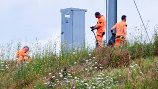 SNCF employees repair the scene of a suspected attack on the Eastern high speed railway network in Vandieres, north eastern France on July 26, 2024, as France’s high-speed rail network was hit by an attack disrupting the transport system, hours before the opening ceremony of the Paris 2024 Olympic Games. 