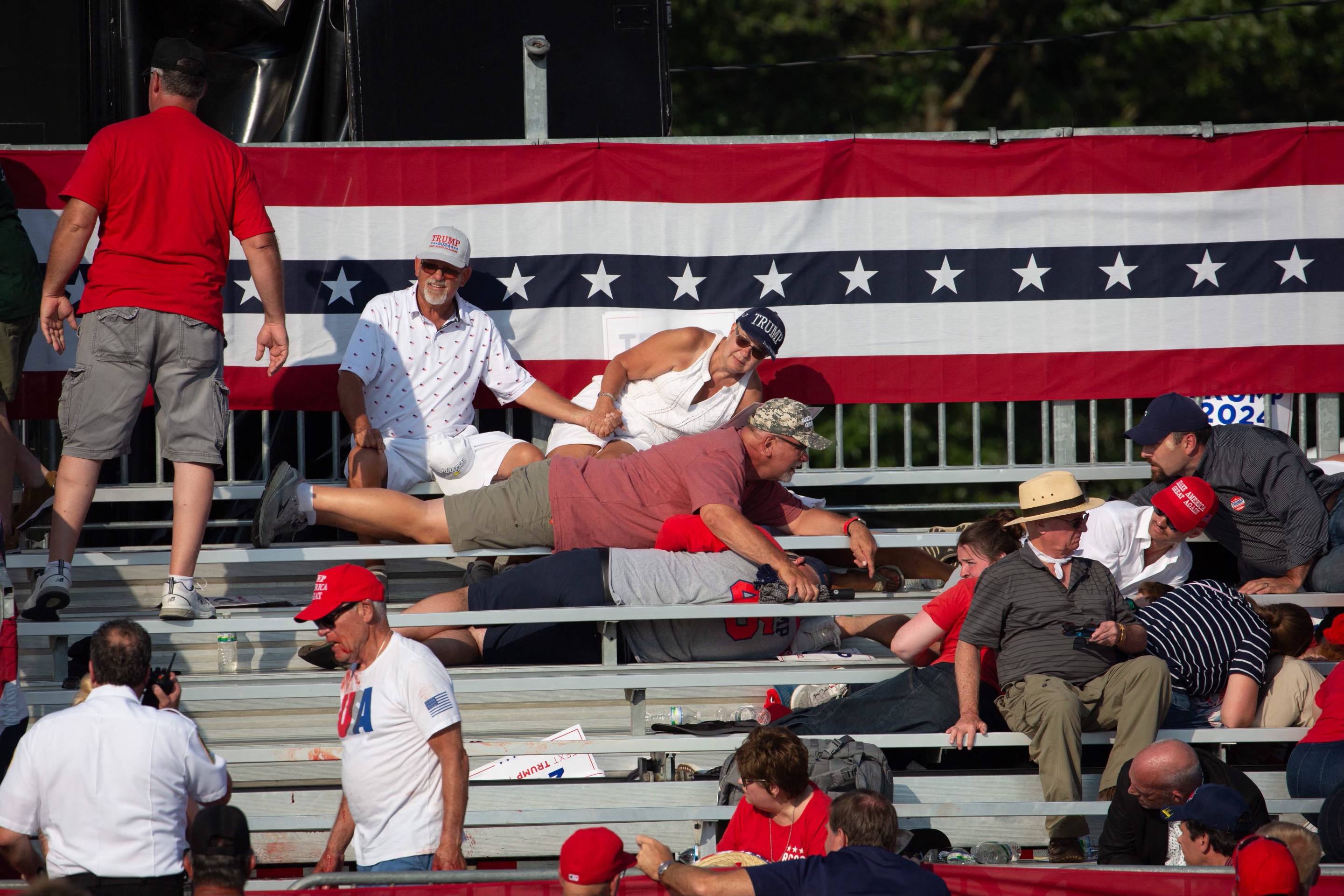 Trump supporters are seen laying in the stands after guns were fired at Republican candidate Donald Trump at a campaign event at Butler Farm Show Inc. in Butler, Pennsylvania, July 13, 2024.