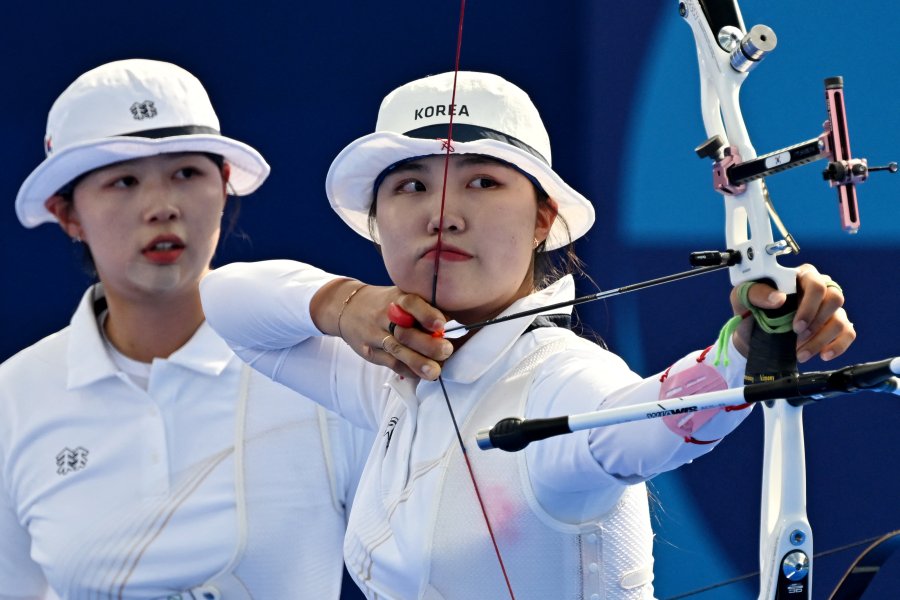 South Korea's Nam Su-hyeon (C) and South Korea's Lim Si-hyeon compete in the archery Women's team final