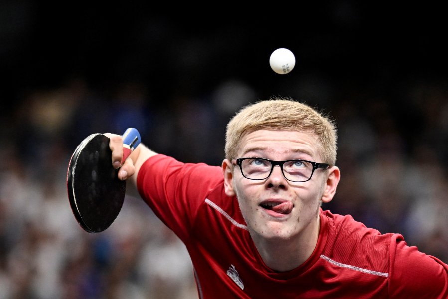 France's Felix Lebrun eyes the ball as he prepares to serve to India's Harmeet Desai during their men's table tennis singles round of 64 at the Paris 2024 Olympic Games.