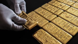 An employee handles one kilogram of gold bullion at the YLG Bullion International Co. headquarters in Bangkok, Thailand, on Friday, Dec. 22, 2023.