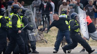 Riot police officers push back anti-migration protesters outside on Aug. 4, 2024 in Rotherham, U.K.