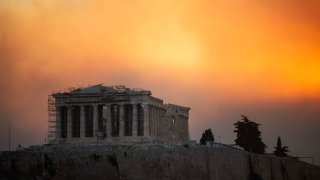 This photograph shows the Parthenon temple atop the Acropolis hill in a smoke cloud from a wildfire, in Athens on August 12, 2024. On August 12, 2024, Greece’s civil protection authorities ordered the evacuation of several towns in the north-eastern suburbs of Athens, threatened by a violent fire that started the day before and is spreading.