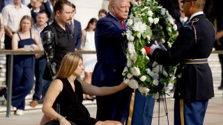 Republican presidential nominee, former U.S. President Donald Trump lays a wreath alongside Marine Cpl. Kelsee Lainhart (Ret.) and and U.S. Marine Corps. Sergeant Tyler Vargas-Andrews (Ret.) who were injured at the Abbey Gate Bombing, during a wreath-laying ceremony at the Tomb of the Unknown Soldier at Arlington National Cemetery on August 26, 2024 in Arlington, Virginia. 