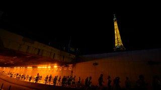 Runners run through an underpass near the Eiffel Tower as they participate in the marathon Pour Tous, at the 2024 Summer Olympics, Saturday, Aug. 10, 2024, in Paris, France.