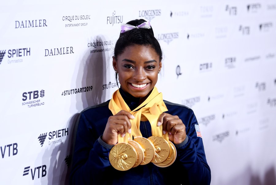 Biles poses with her multiple gold medals