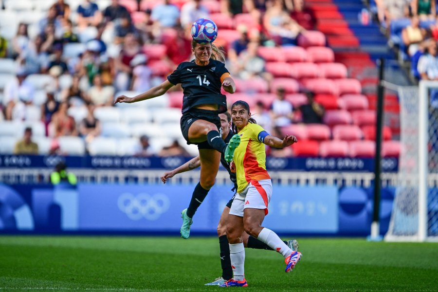 New Zealand's defender #14 Katie Bowen (L) jump for the ball  flanked by  Colombia's forward #11 Catalina Usme  during the women's group A football match between New Zealand and Colombia