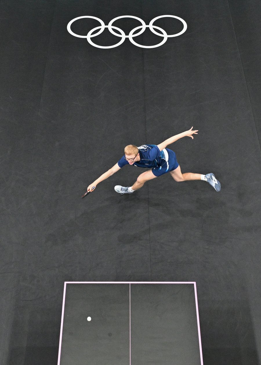 An overview shows France's Felix Lebrun returning the ball during their men's table tennis singles match in the team semifinal between China and France at the Paris 2024 Olympic Games at the South Paris Arena in Paris on August 8, 2024