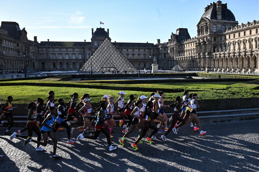 Athletes run past Pyramide du Louvre, designed by Chinese-US architect Ieoh Ming Pei, as they compete in the women's marathon of the athletics event at the Paris 2024 Olympic Games in Paris on August 11, 2024