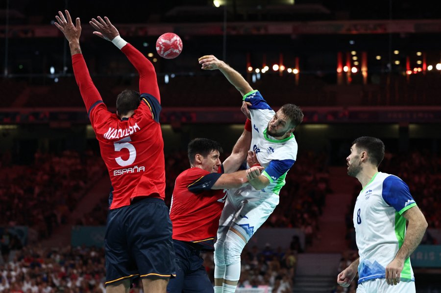 Slovenia's left back #88 Aleks Vlah shoots past Spain's pivot #20 Abel Serdio (2ndL) during the men's bronze medal handball match between Spain vs Slovenia of the Paris 2024 Olympic Games, at the Pierre-Mauroy stadium in Villeneuve-d'Ascq, northern France, on August 11, 2024