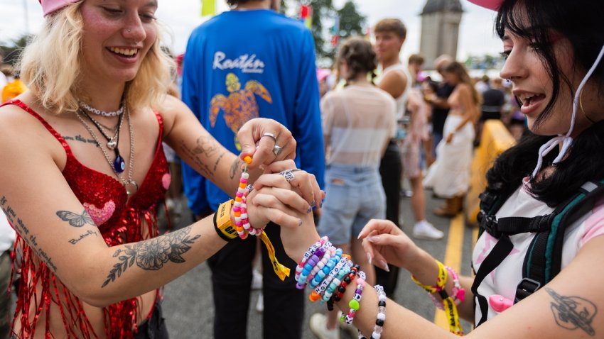 Madyson McAlvey, 24, of Greenville, Michigan, left, trades a bracelet with Rayne Schielke, 21, of Springfield, Missouri, outside the Van Buren Street entrance before gates open at Lollapalooza in Chicago’s Grant Park on Thursday, Aug. 1, 2024. (Tess Crowley/Chicago Tribune/Tribune News Service via Getty Images)