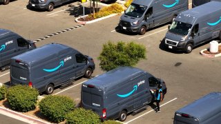 In an aerial view, Amazon delivery trucks sit parked at an Amazon distribution center in Richmond, California, on July 16, 2024.