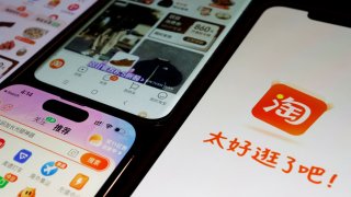 The logo of Alibaba’s e-commerce app Taobao is displayed next to mobile phones displaying the app, in this illustration picture taken October 25, 2023.