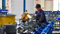 A worker assembling a loader transmission mechanism at a manufacturer in Qingzhou, China.