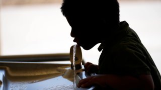 A student drinks from a water fountain