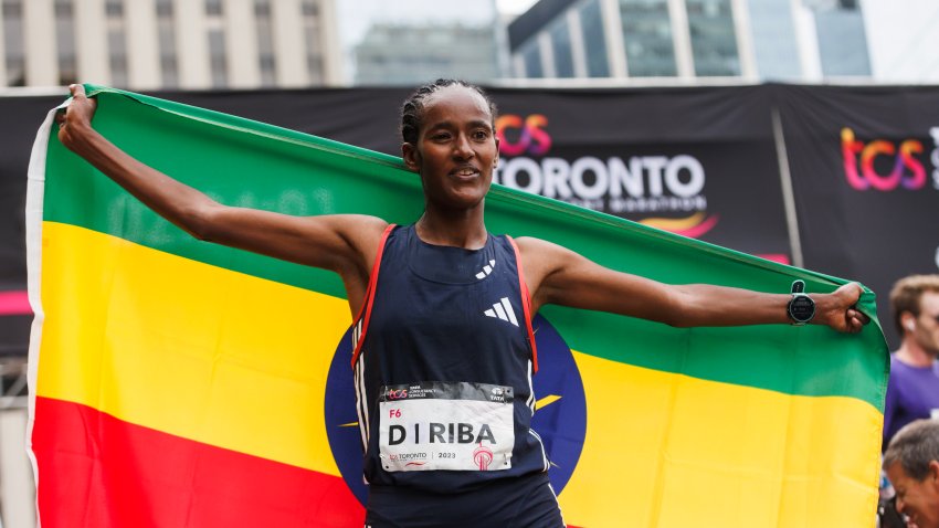 TORONTO, CANADA – OCTOBER 15: Buze Diriba Kejela of Ethiopia poses with the Ethiopian flag after crossing he finish line to place first in the Pro Women’s category of the Toronto Waterfront Marathon on October 15, 2023 in Toronto, Canada. (Photo by Cole Burston/Getty Images)