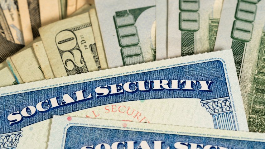 USA Social security cards laid on pile of dollar bills to illustrate money in retirement