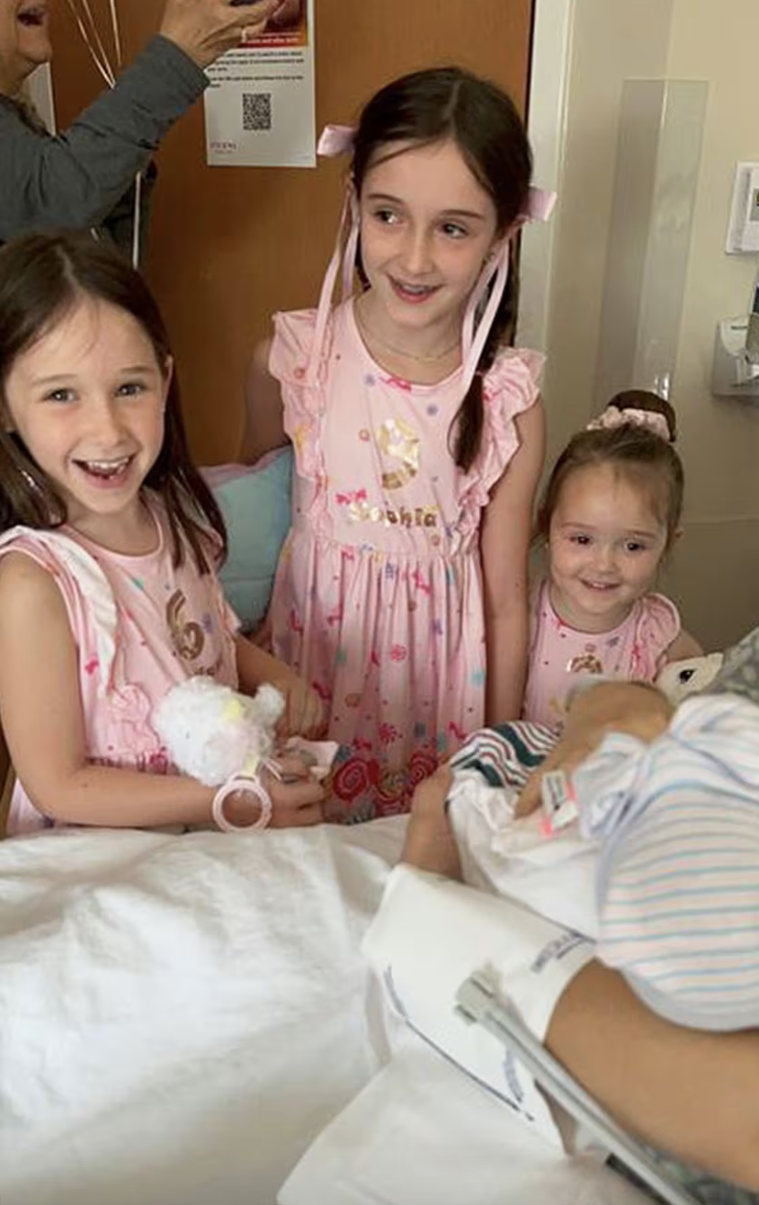 The older Lammert girls meet their newest birthday buddy in the hospital just hours after her arrival.