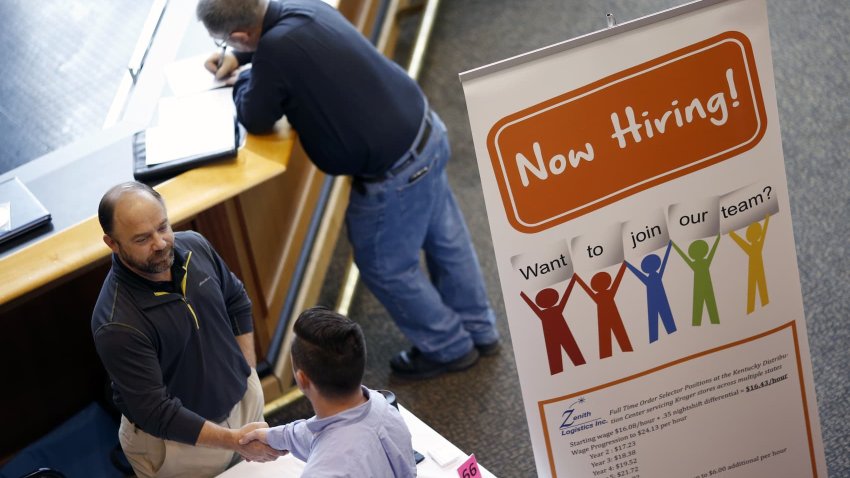 A representative, left, shakes hands with a job seeker during a Job News USA career fair.