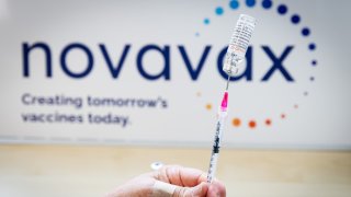 A health worker prepares a dose of the Novavax vaccine as the Dutch Health Service Organization starts with the Novavax vaccination program on March 21, 2022 in The Hague, Netherlands.