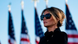 Outgoing First Lady Melania Trump listens as her husband Outgoing US President Donald Trump addresses guests at Joint Base Andrews in Maryland on January 20, 2021.