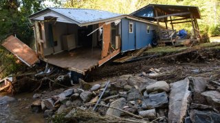 Damage to homes and vehicles along with evidence of re-routed streams can be seen on October 2, 2024 in Black Mountain, North Carolina.