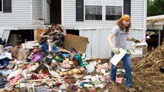 Ryan Creel takes a sewing machine from a pile of damaged belongings on October 4, 2024 in Camden, North Carolina. 