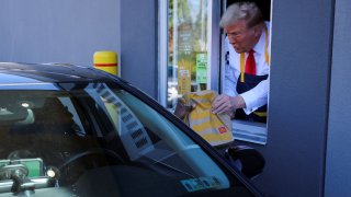 Republican presidential nominee and former U.S. President Donald Trump serves food at a McDonalds restaurant in Feasterville-Trevose, Pennsylvania, U.S. October 20, 2024. 