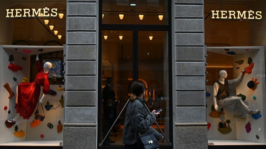 A woman walks past a Hermes boutique in Via Monte Napoleone, a famous upscale shopping street in Milan.