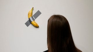 People look at Italian visual artist Maurizio Cattelan’s duct-taped Banana entitled “Comedian,” during a press preview at Sotheby’s in New York, on October 25, 2024. The viral artwork was unveiled in 2019, and one of the artwork’s three “editions” is going back on sale on November 20, 2024, and is estimated by Sotheby’s to sell for between $1m and $1.5m.