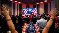 Attendees cheer as a broadcast of former US President and Republican presidential candidate Donald Trum speaking at his Florida election party is shown on a screen at the Nevada GOP election watch party in Las Vegas, Nevada on November 6, 2024. 