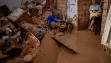 Dolores Merchan, 67, looks down on her mud-splattered belongings from the house where she has lived all her life with her husband and three children, and which has been severely affected by the floods in Masanasa, Valencia, Spain, Thursday, Nov. 7, 2024. (AP Photo/Emilio Morenatti)