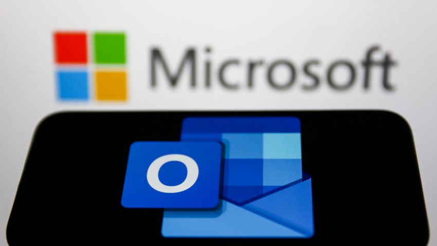 Microsoft Outlook logo displayed on a phone screen and Microsoft logo displayed on a screen in the background are seen in this illustration photo taken in Krakow, Poland on May 26, 2022. (Photo Illustration by Jakub Porzycki/NurPhoto via Getty Images)