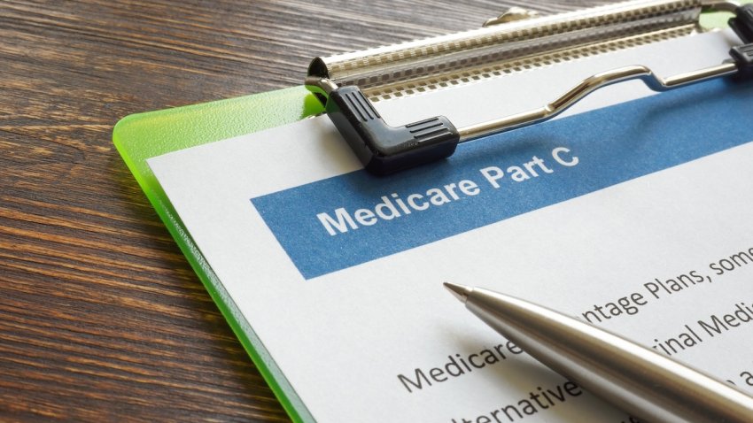 Medicare part C insurance papers with clipboard and pen.