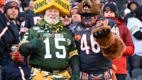 CHICAGO, ILLINOIS – DECEMBER 04: A Green Bay Packers fan and a Chicago Bears fan cheer on during the second half of the game at Soldier Field on December 04, 2022 in Chicago, Illinois. (Photo by Quinn Harris/Getty Images)