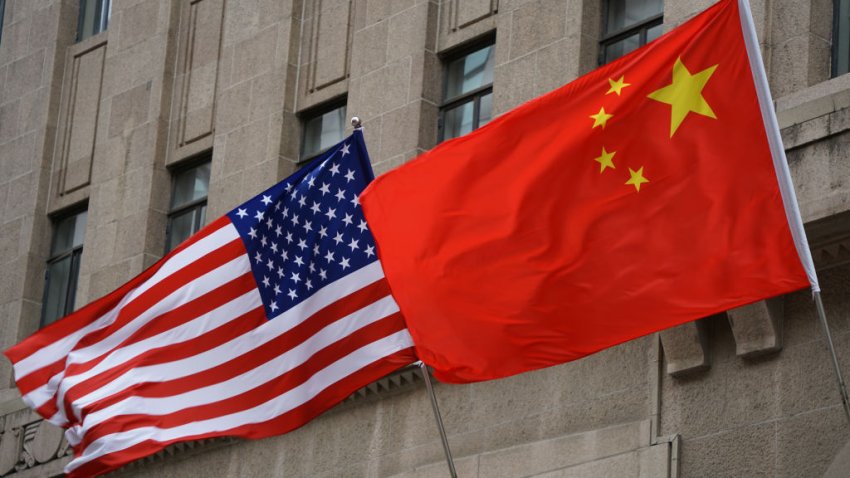 The national flags of the United States and China flutter at the Fairmont Peace Hotel on April 25, 2024 in Shanghai, China.