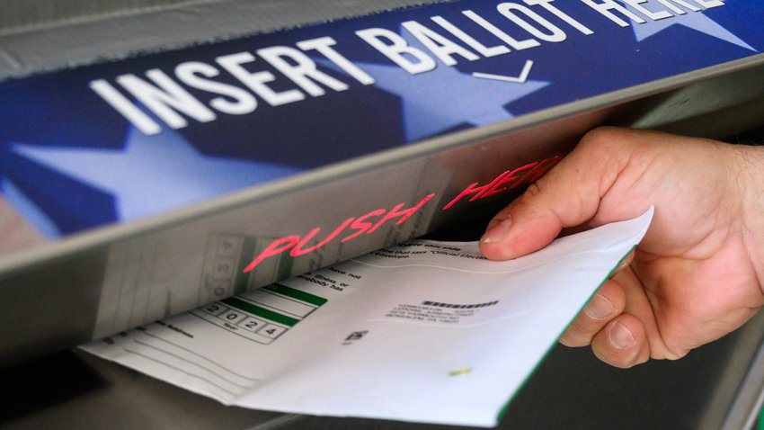 A voter uses a ballot drop box at the Bucks County Administration building voting on demand and ballot drop center in Doylestown, Pennsylvania, Oct. 31, 2024.